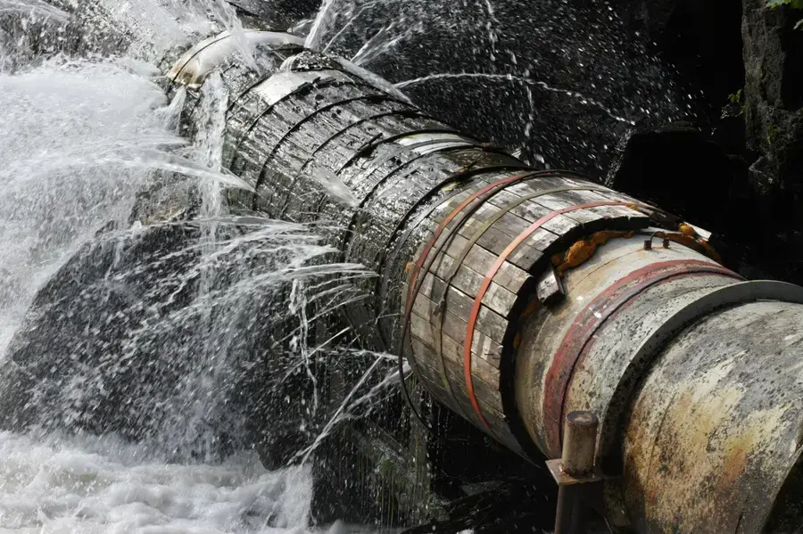 Old pipe spraying water from a burst joint